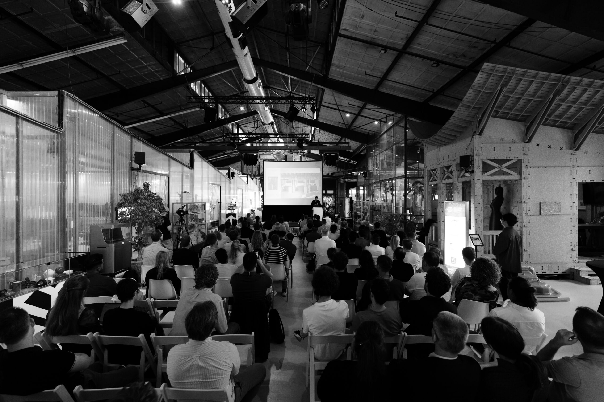 The main floor of 3D Makers Zone in Haarlem during Addidex Connect 2026, with industrial robot arms and a seated audience