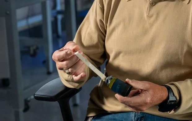 Samuel Larter holds a submunition with the 3D printable clip attached