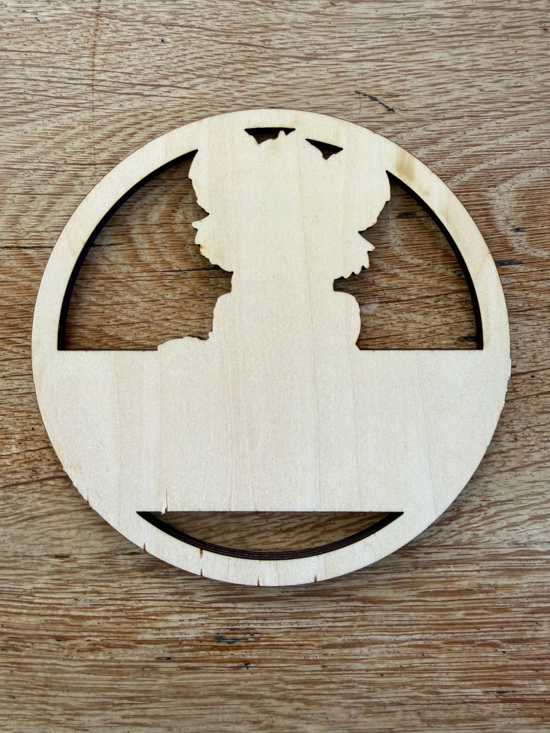 The plywood offcut from the name plate, showing the clean cut edges and the tiger silhouette
