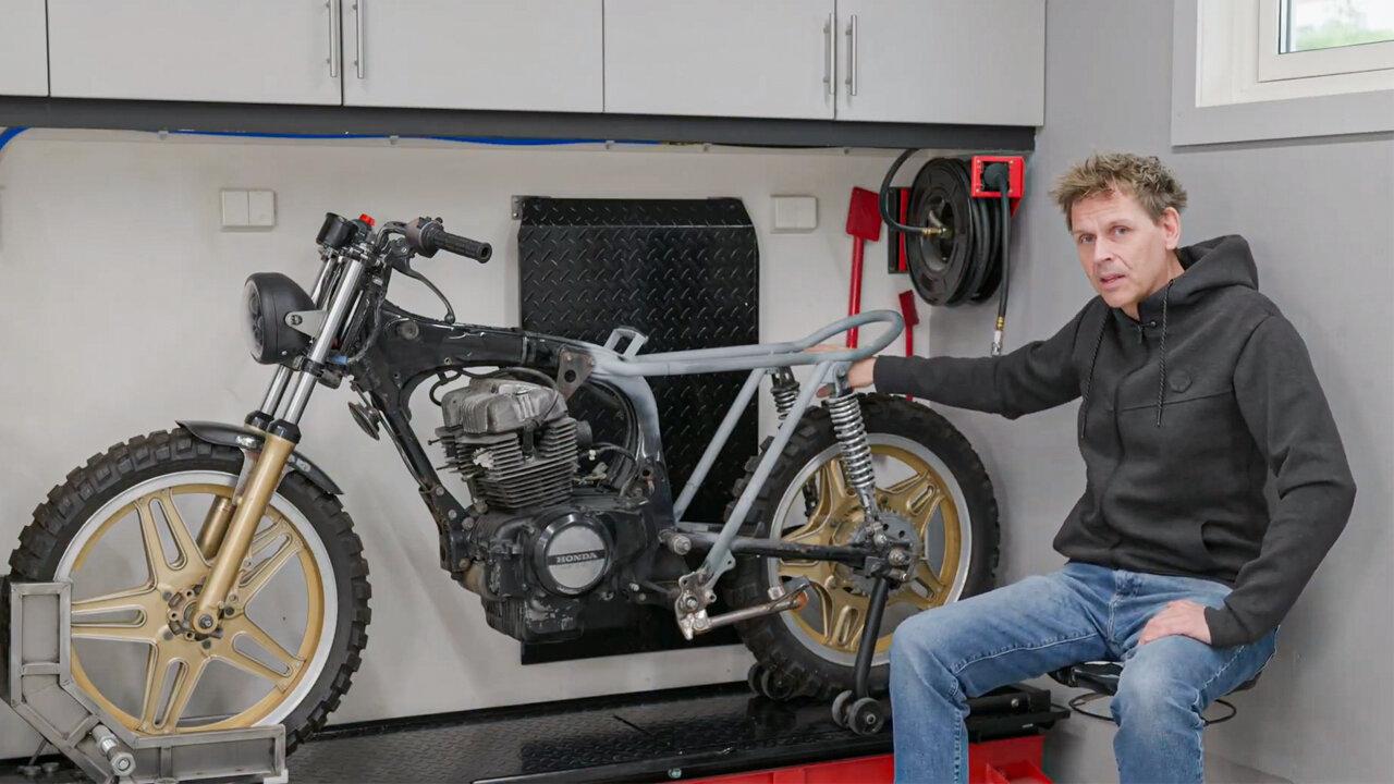 The builder with the modified 1984 Honda CB400 rear subframe in his workshop