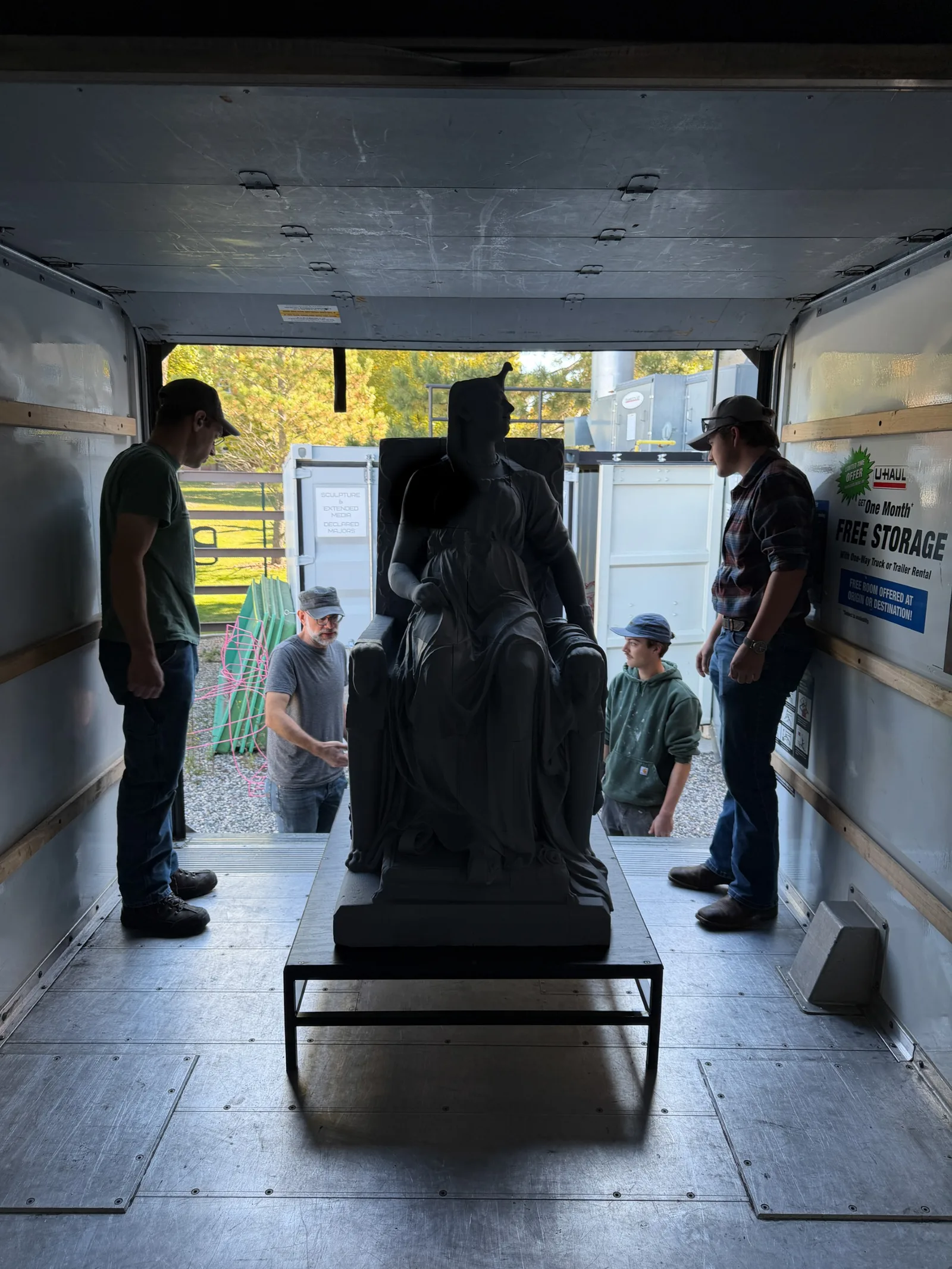 People unload the 3D printed statue