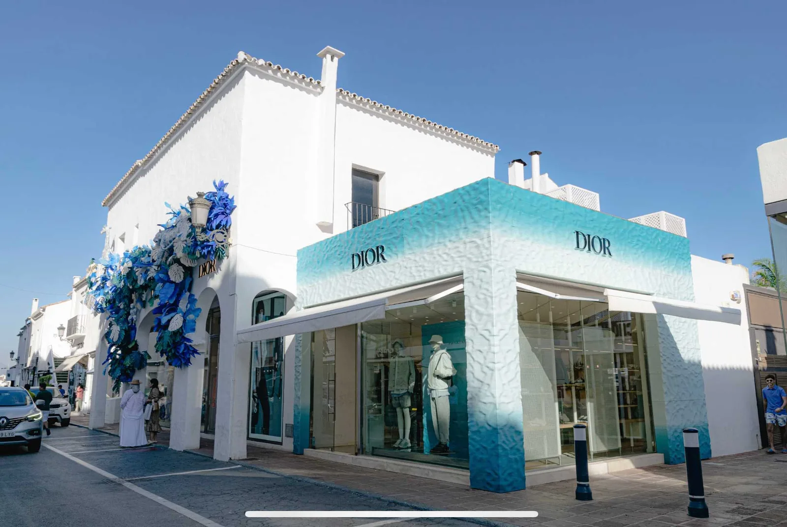 Dior store with a blue and white printed facade on a whitewashed street