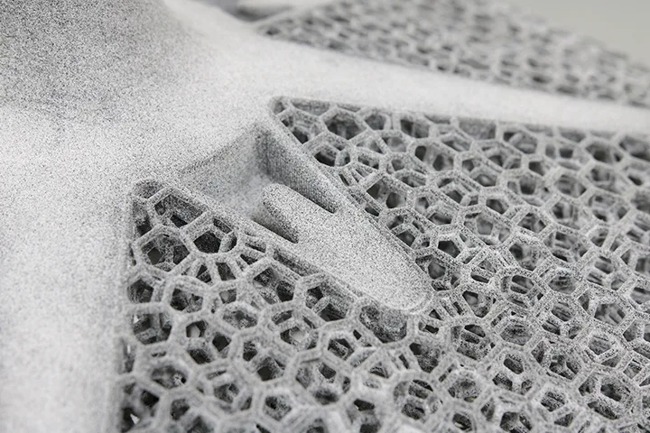 Close-up of a grey part combining lattice and solid sections