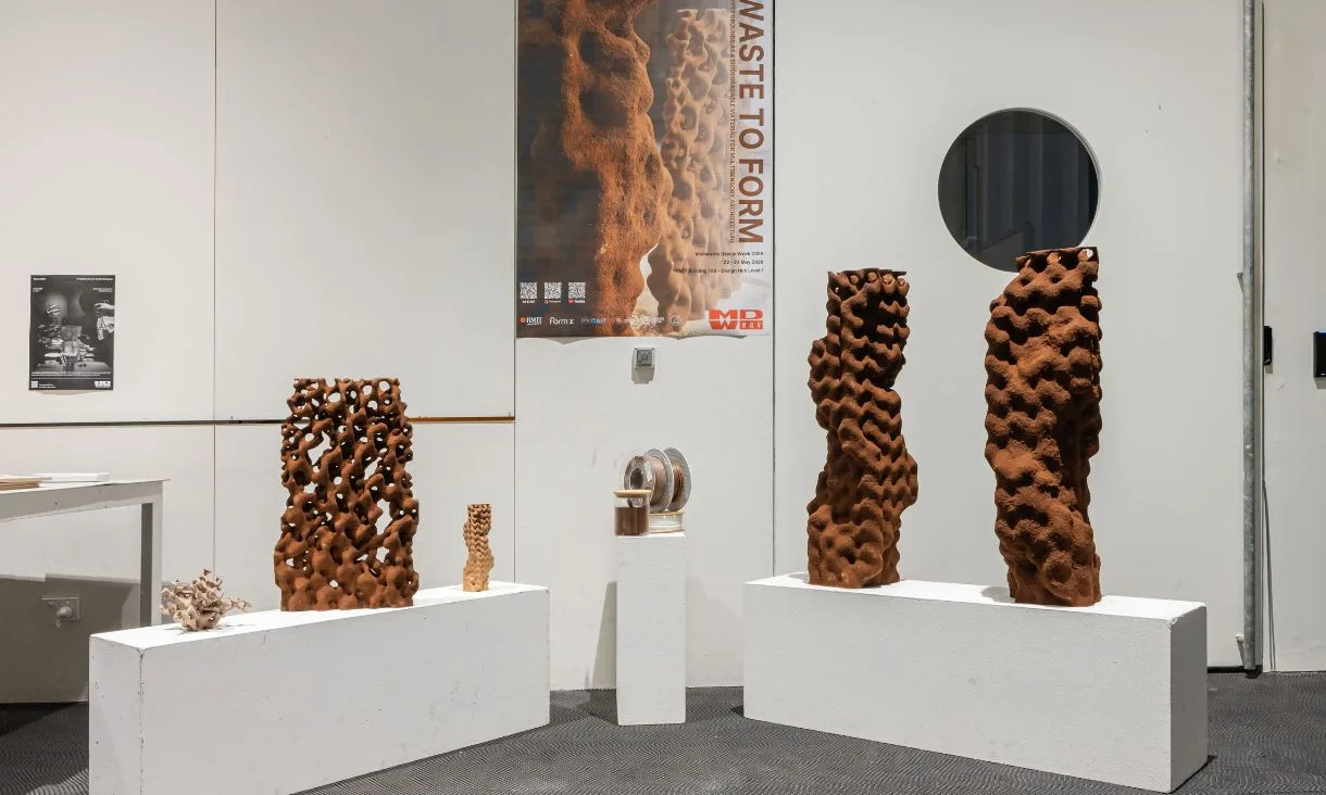 Brown printed coffee waste forms on white plinths in an exhibition space