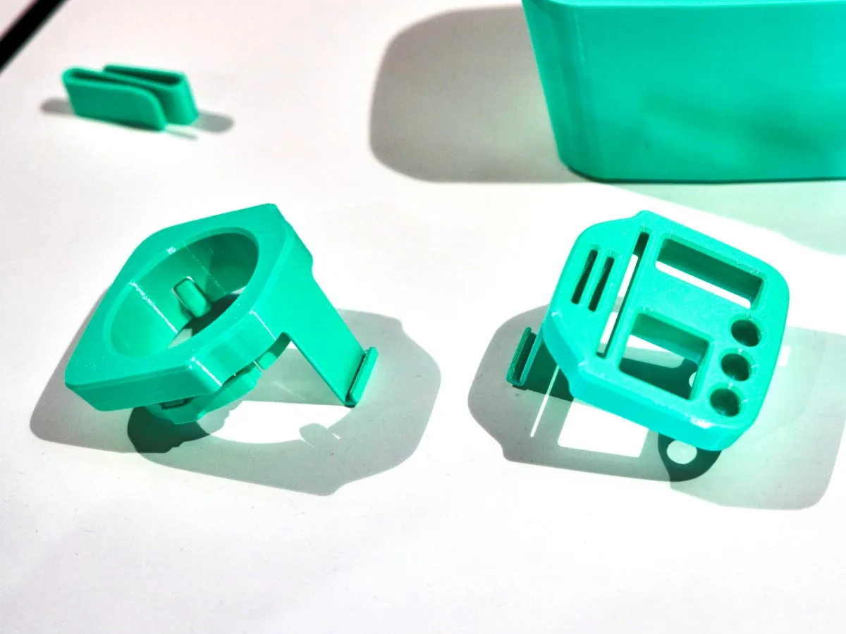 Turquoise 3D printed cupholder inserts on a white surface