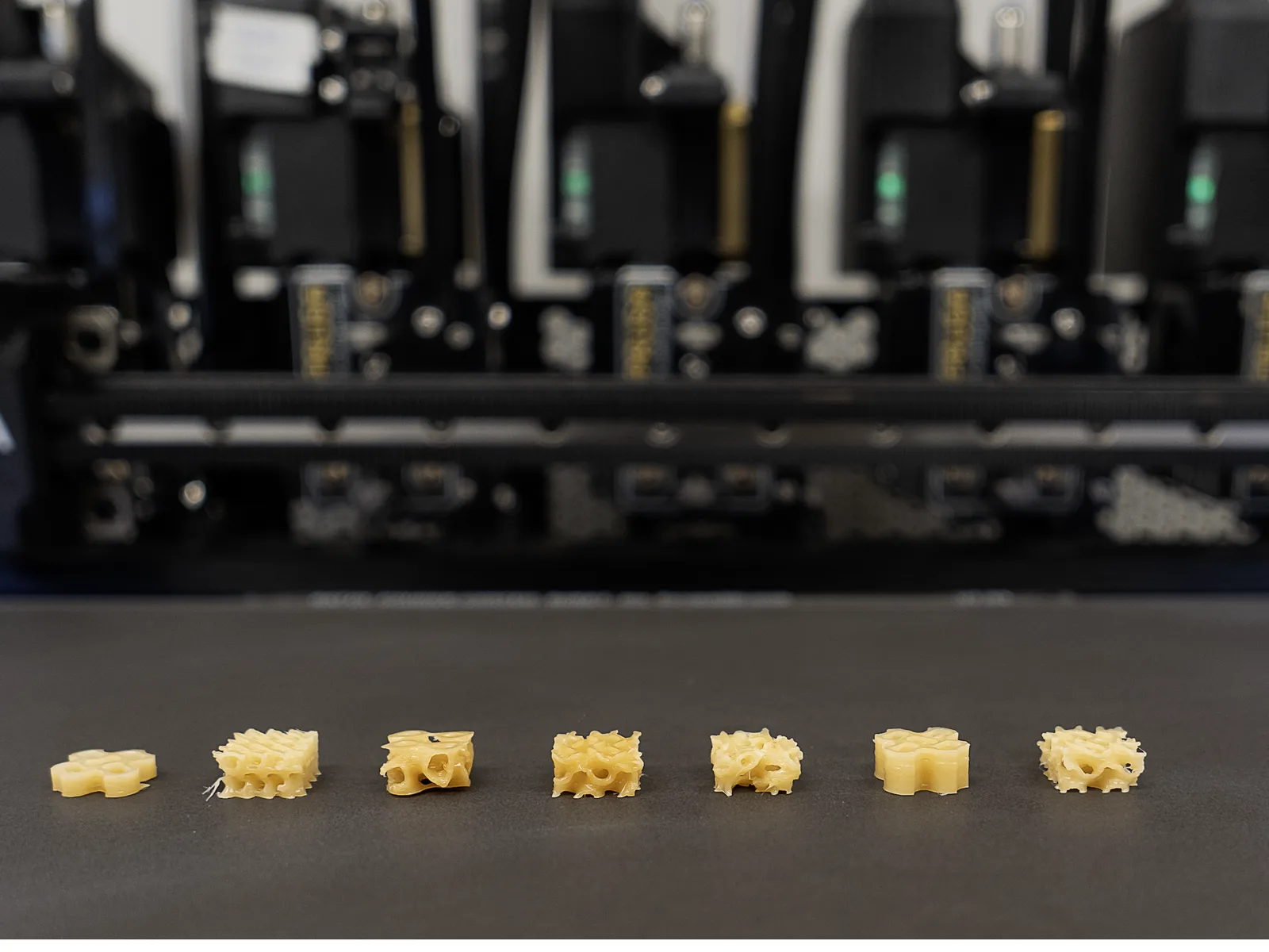 Row of small 3D printed lattice samples made from the okara-based biomaterial