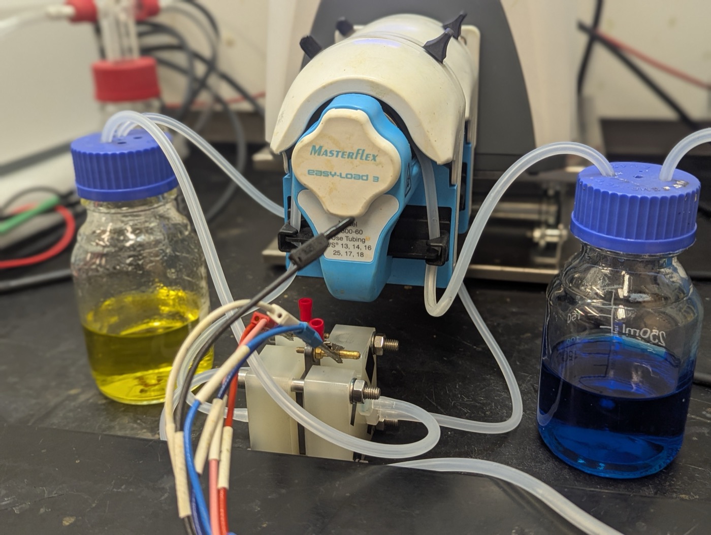 Laboratory redox flow battery setup with tanks, pump, and reactor